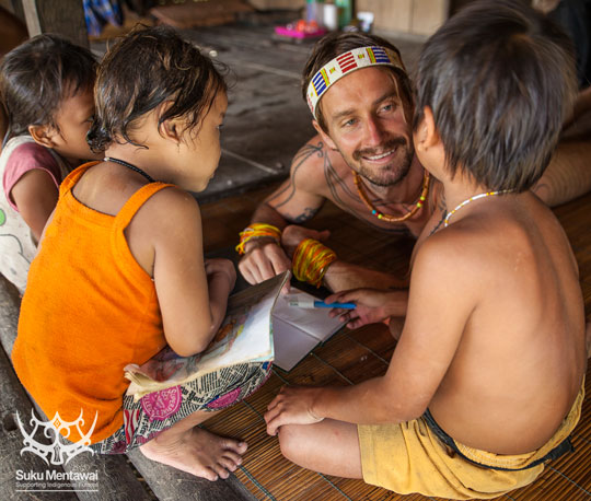 IEF Direktur, Rob Henry, bekerja pada sebuah buku pendidikan budaya dengan anak-anak Mentawai