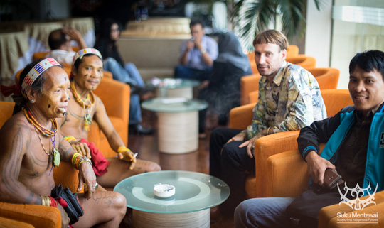 Mentawai Sikerei sitting at the Hotel Grand Inna in Padang in their loincloth and traditional clothing